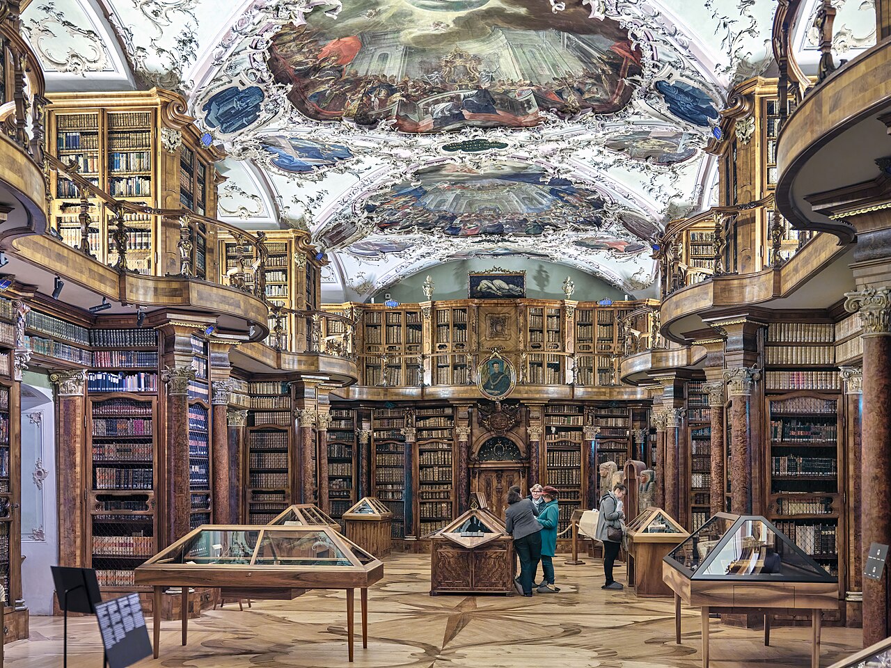 Blick in den Barocksaal der Stiftsbibliothek St. Gallen mit historischen Büchern und Besucherinnen und Besuchern